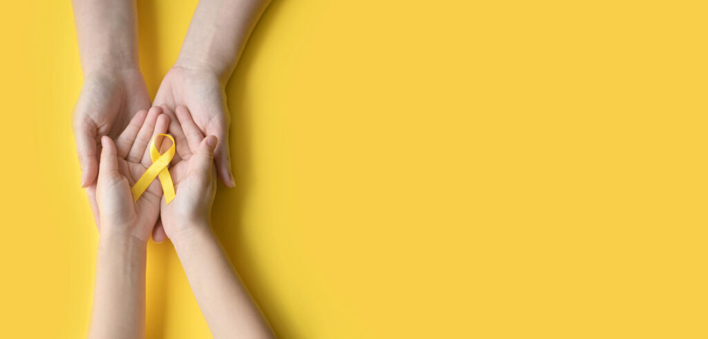 Two sets of hands with a yellow ribbon
