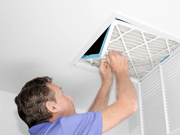 HVAC technician replacing air filter