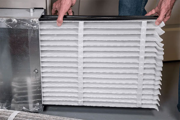 Technician replacing HVAC air filter