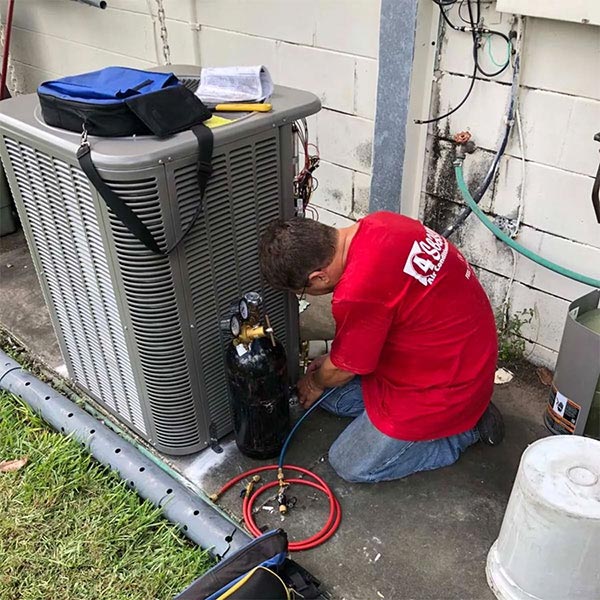 4 Seasons Air Conditioning and Heating technician servicing an HVAC unit